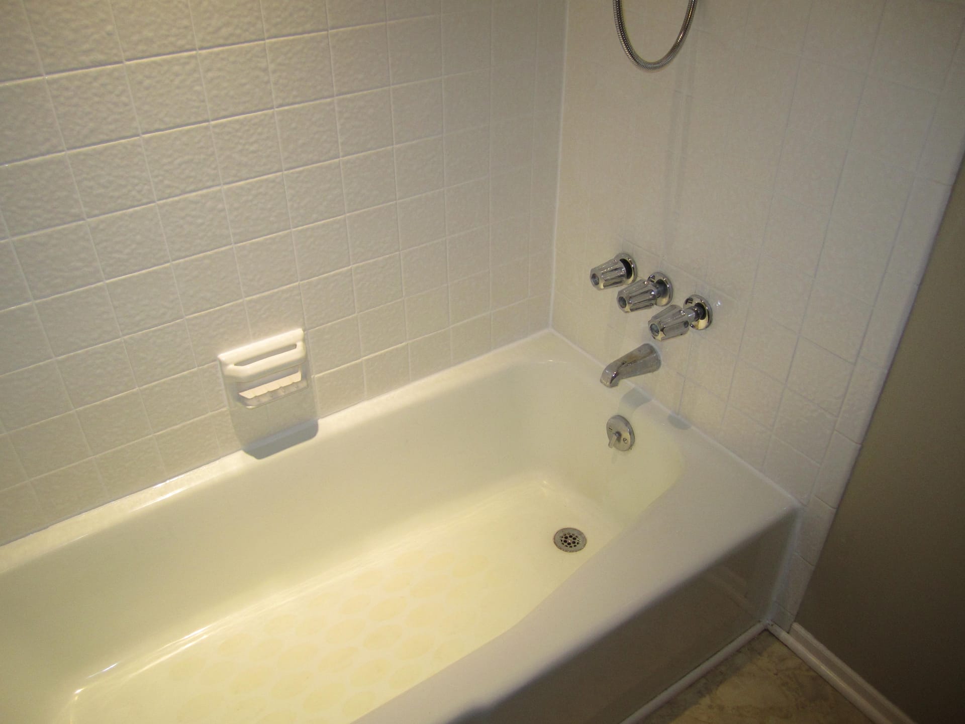 After: Tub surround, grout and caulk back to white